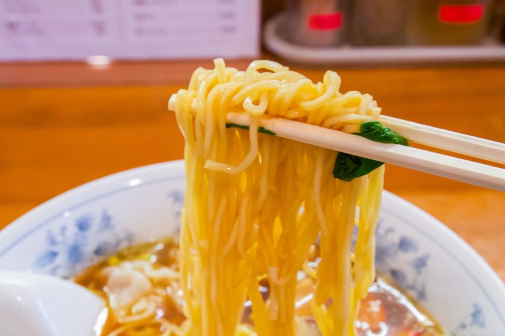 a bowl of noodles with chopsticks sticking out of it