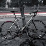 red and black road bike parked beside road